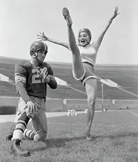 Mamie Van Doren Kicking on Football Field with Jim Sears