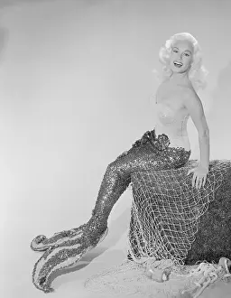 Mamie Van Doren Sitting on Rock in Mermaid Suit