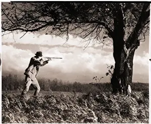 Aiming Prints: Man Aiming Rifle at Tree