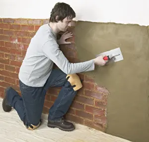 Brick Wall Prints: Man applying waterproof render to a wall with a trowel