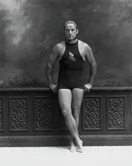Man in Bathing Suit Leaning Against Wall
