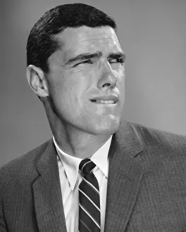 Man biting lip and squinting