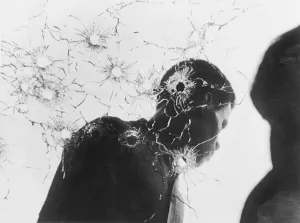 Shattered Prints: Man Behind Bullet-Riddled Glass