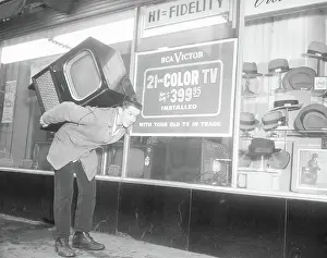 On Sale Prints: Man Carrying Television On Back