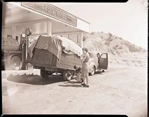 Tire Prints: Man Checks Trailer Tires at Gas Station