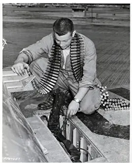 Checking Prints: Man Cleans & Checks Machine Guns