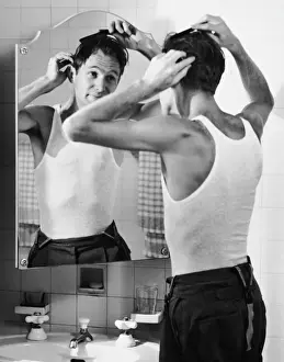 Man combing hair in bathroom