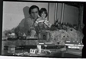 Man and Daughter Running Toy Trains