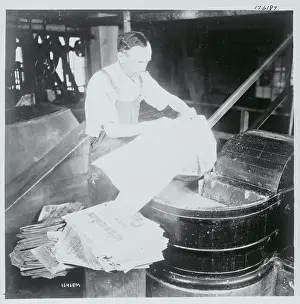 Man De-Inking Old Newspapers