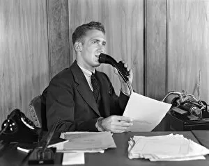 Man at desk talking into Dictaphone