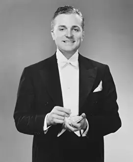 Series Prints: Man in dinner jacket holding cigarette and cigarette case standing in studio