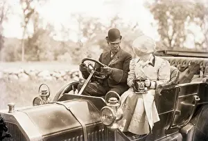 Steering Wheel Prints: Man Drives Auto While Woman Snaps Photo