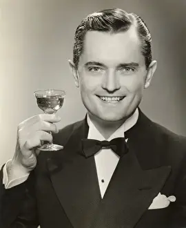Man in evening clothes raising glass