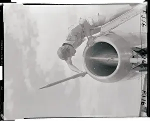 Man Examining a Tube on the Nose of a Jet
