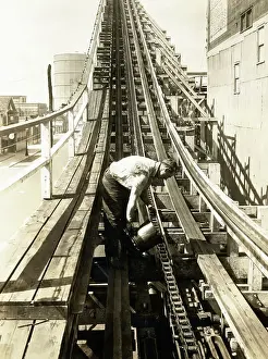 Amusement Park Prints: Man Greasing Chain Of Wood Roller Coaste