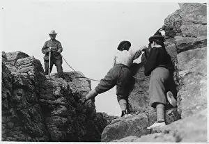 Man Helping Women on Mountainous Rock