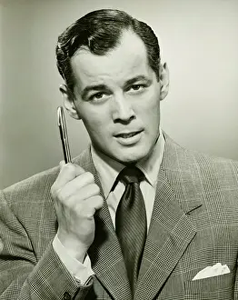 30 35 Years Prints: Man holding ballpoint, posing in studio, (B&W), portrait