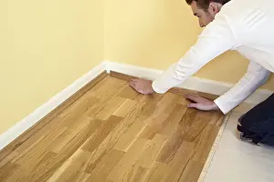 Kneeling Prints: Man holding piece of quadrant on laminate flooring