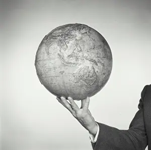 Pacific Prints: Man holding a relief globe in air