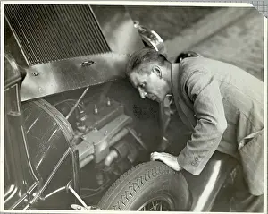 Tire Prints: Man Inspecting Motor of Used Automobile