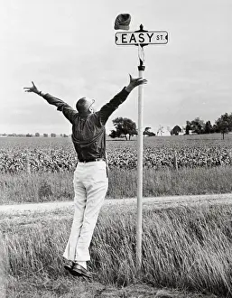 Good Luck Prints: Man Jumping for Joy Near Sign for Easy Street