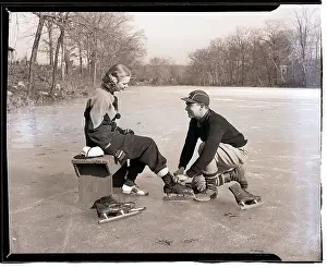 Ice Skating Prints: Man Lacing a Woman's Ice Skate