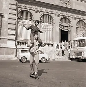 Skating Prints: Man with Lady on Shoulders Riding Skateboard