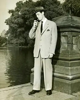 Lighter Prints: Man lighting cigarette by lake in park, (B&W)