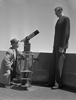 Man Looking at Wadlow Through Telescope