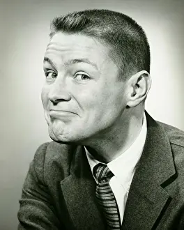 Man making face in studio, (B&W), close-up