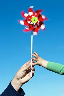 Environmental Prints: Man passing a wind wheel to a child