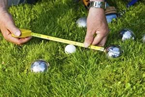 70 79 Years Prints: Man playing boules, petanque, measuring the distances between the balls