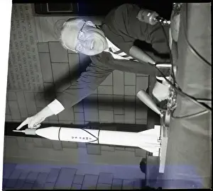 Man Pointing To Top Of Missile Model