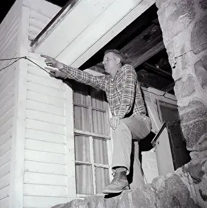 Man On Porch Pointing Toward Sky