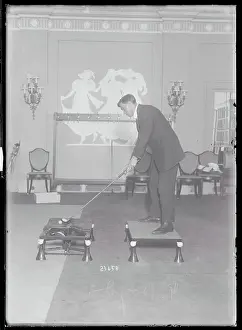 Lodgings Prints: Man Practicing His Golf Skills Indoors