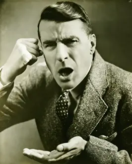 Performing Prints: Man pretending phone talk in studio, (B&W)