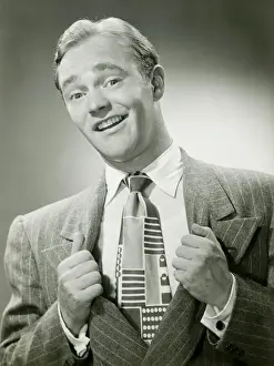 Raised Eyebrow Prints: Man pulling sides of jacket apart to reveal tie, portrait