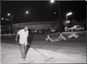 Sweeping Prints: Man Pushing Brooms After Riot