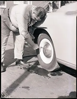 Tire Prints: Man Putting Air in Automobile Tire