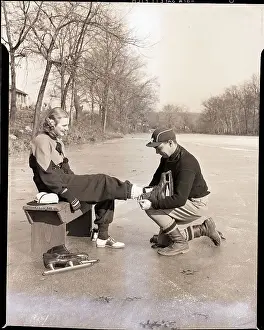 Ice Skating Prints: Man Putting on Woman's Ice Skates