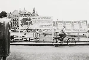 Man Riding Past Communist Posters