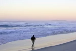 Man running on beach, dawn, (blurred motion)