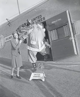 Burbank Prints: Man in Santa Claus Costume Unloading Toys