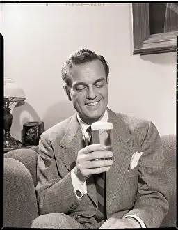 Indulgence Prints: Man Sitting on Couch with Glass of Beer