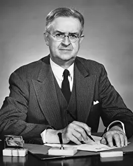 Man sitting at desk, holding pen