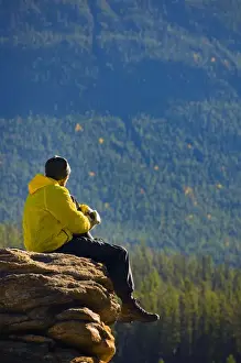 Reflective Prints: Man sitting on a mountain in Jasper National Park, Alberta