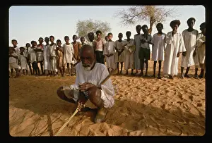 Man Squatting in Front of Children