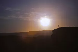 Images Dated 15th July 2012: Man standing on the edge of a cliff at sunset, Valle de la Luna, San Pedro de Atacama, Chile
