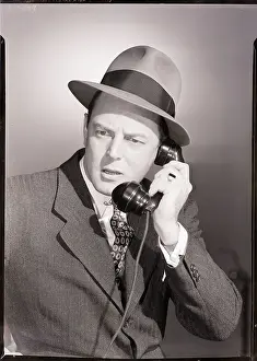 Man in Suit and Hat Using Telephone