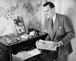 Business Travel Collection: Man taking folded shirt from drawer (B&W)
